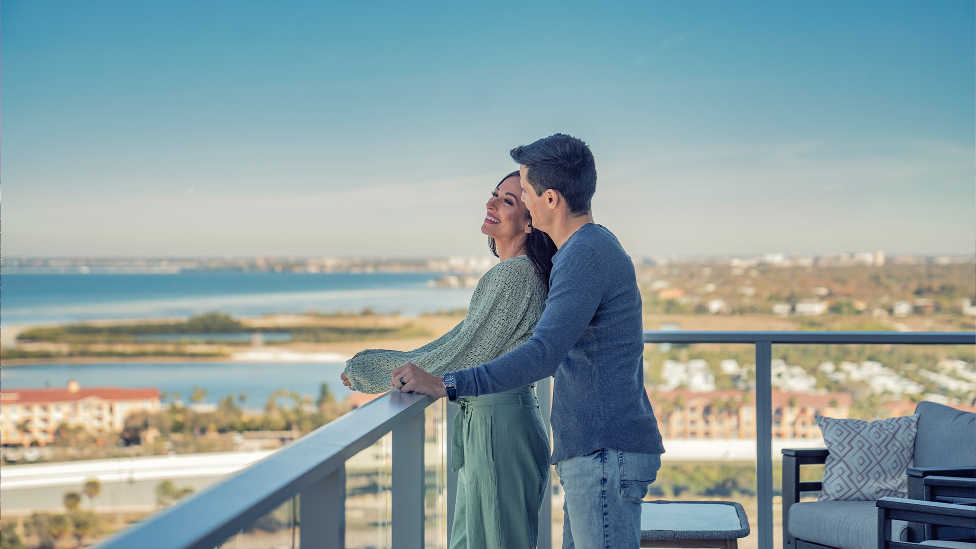 couple looking out to the Tampa Bay area from luxury condo terrace