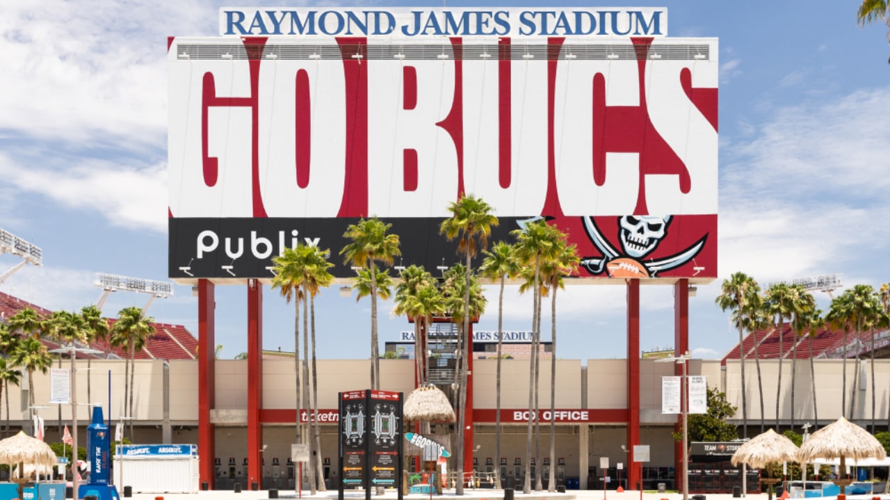 Raymond James Stadium in Tampa with Go Bucs sign and palm trees