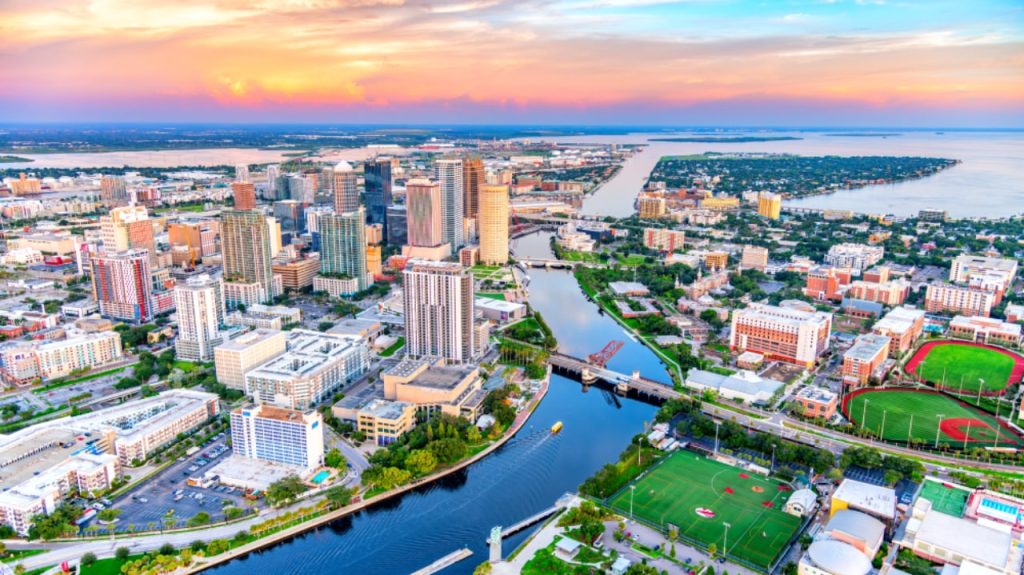 Aerial view of Tampa Bay downtown skyline with river and colorful sunset