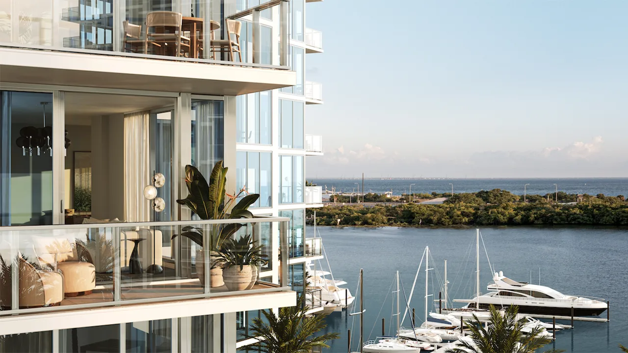 Balcony view of waterfront with boats and distant shoreline.