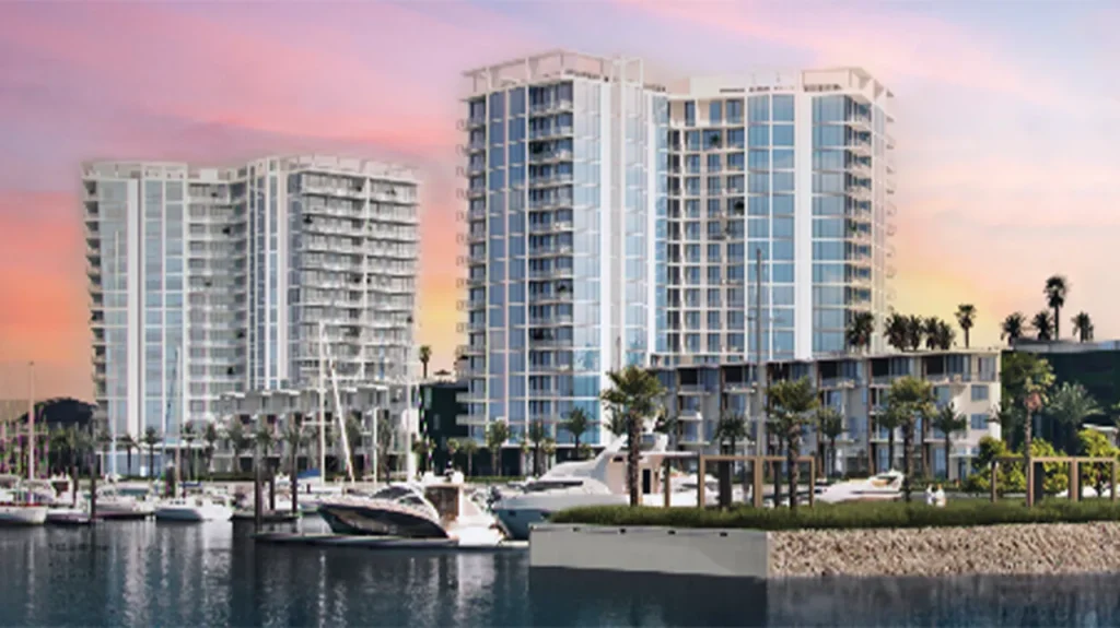 Waterfront buildings at sunset with boats docked in front.